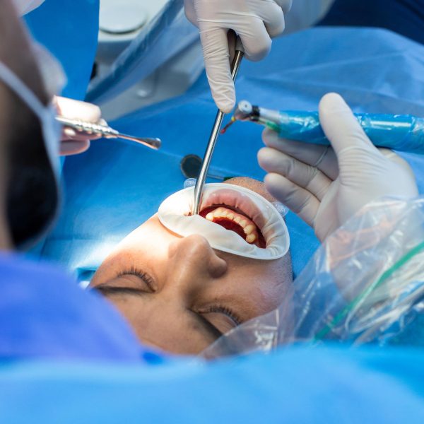 dentist and assistant with tool makes some manipulations in the patient's mouth